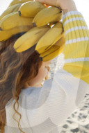Summer Fashion: Girl with curly and red Hair carries Bananas on her Head