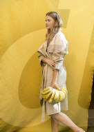 Summer Fashion: Woman in Trenchcoat holding Bananas
