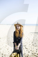 Summer Fashion: Girl with curly and red Hair holding a Bag of Bananas