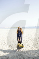 Summer Fashion: Girl with curly and red Hair holding a Bag of Bananas