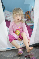 Blonde Girl girl sitting in a Tent looking outside