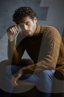 Anxious young Man wearing a brown Turtleneck Pullover