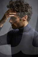 Anxious young Man wearing blue Turtleneck