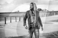Lonesome Man at the Beach wearing a hooded Jacket