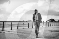 Lonesome Man at the Beach wearing a hooded Jacket
