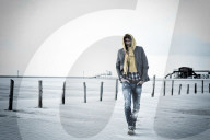Lonesome Man at the Beach wearing a hooded Jacket