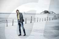 Lonesome Man at the Beach wearing a hooded Jacket