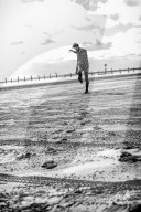 Lonesome Man at the Beach kicking Stones