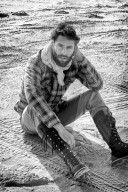 Lonesome Man at the Beach sitting on the Ground