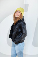 Portrait of a Woman with curly Hair wearing a yellow Beanie