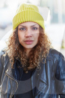 Portrait of a Woman with curly Hair wearing a yellow Beanie