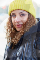 Portrait of a Woman with curly Hair wearing a yellow Beanie