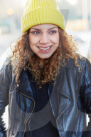 Portrait of a Woman with curly Hair wearing a yellow Beanie