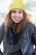 Portrait of a Woman with curly Hair wearing a yellow Beanie