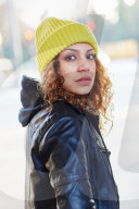 Portrait of a Woman with curly Hair wearing a yellow Beanie