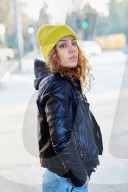 Portrait of a Woman with curly Hair wearing a yellow Beanie
