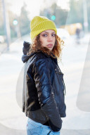 Portrait of a Woman with curly Hair wearing a yellow Beanie