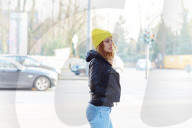 Portrait of a Woman with curly Hair wearing a yellow Beanie