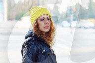 Portrait of a Woman with curly Hair wearing a yellow Beanie