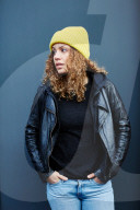 Portrait of a Woman with curly Hair wearing a yellow Beanie