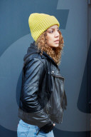 Portrait of a Woman with curly Hair wearing a yellow Beanie