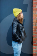 Portrait of a Woman with curly Hair wearing a yellow Beanie