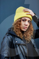 Portrait of a Woman with curly Hair wearing a yellow Beanie