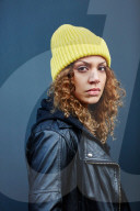 Portrait of a Woman with curly Hair wearing a yellow Beanie