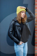Portrait of a Woman with curly Hair wearing a yellow Beanie