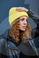 Portrait of a Woman with curly Hair wearing a yellow Beanie