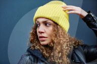 Portrait of a Woman with curly Hair wearing a yellow Beanie