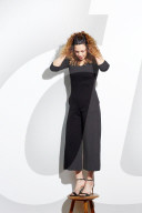 Portrait of a Woman with curly Hair balancing on a Stool