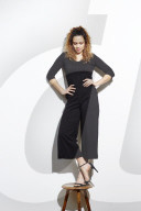 Portrait of a Woman with curly Hair balancing on a Stool
