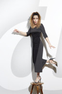 Portrait of a Woman with curly Hair balancing on a Stool