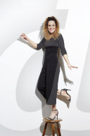 Portrait of a Woman with curly Hair balancing on a Stool