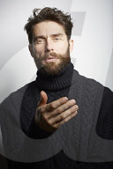 Portrait of a Man wearing a black Turtleneck and discussing a Topic