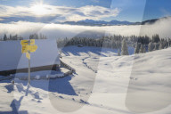View over a snow covered alpine hut and alpine meadows