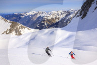 Couple skiiing downhill