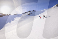 Couple skiiing downhill