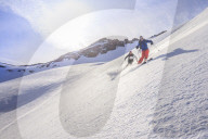 Couple skiiing downhill
