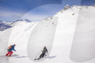 Couple skiiing downhill