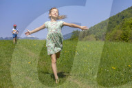 Girl and Boy running up and down a Meadow nearby Salzburg