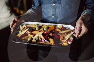 Man holding a Casserole Dish with mixed Vegetables