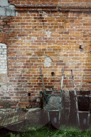 Wheelbarrows leaning against a Brick Wall