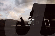 Woman sitting on a Jeep at Sundown