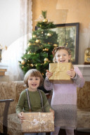 Excited Siblings holding Presents in their Hands on Christmas Day