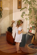 Girl dressed up as an Angel watches herself in a Mirror