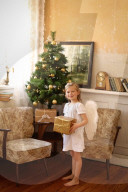 Girl dressed up as an Angel holding a Present in her Hands at Christmas Day