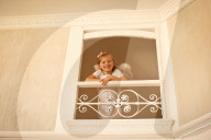 Girl dressed up as an Angel looking Down from a Balustrade