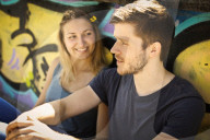 Couple sitting in front of a Graffiti Wall